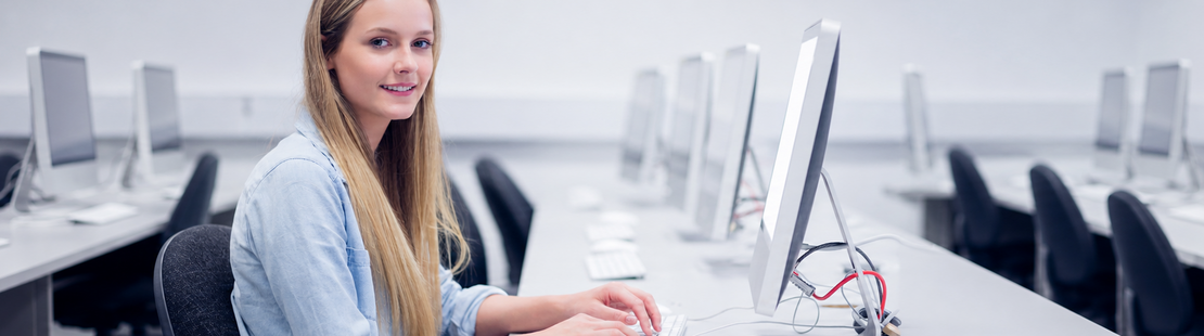 Imagebild für Testzentren. Eine junge Frau sitzt an einem Rechner im Computerraum eines Testzentrums.